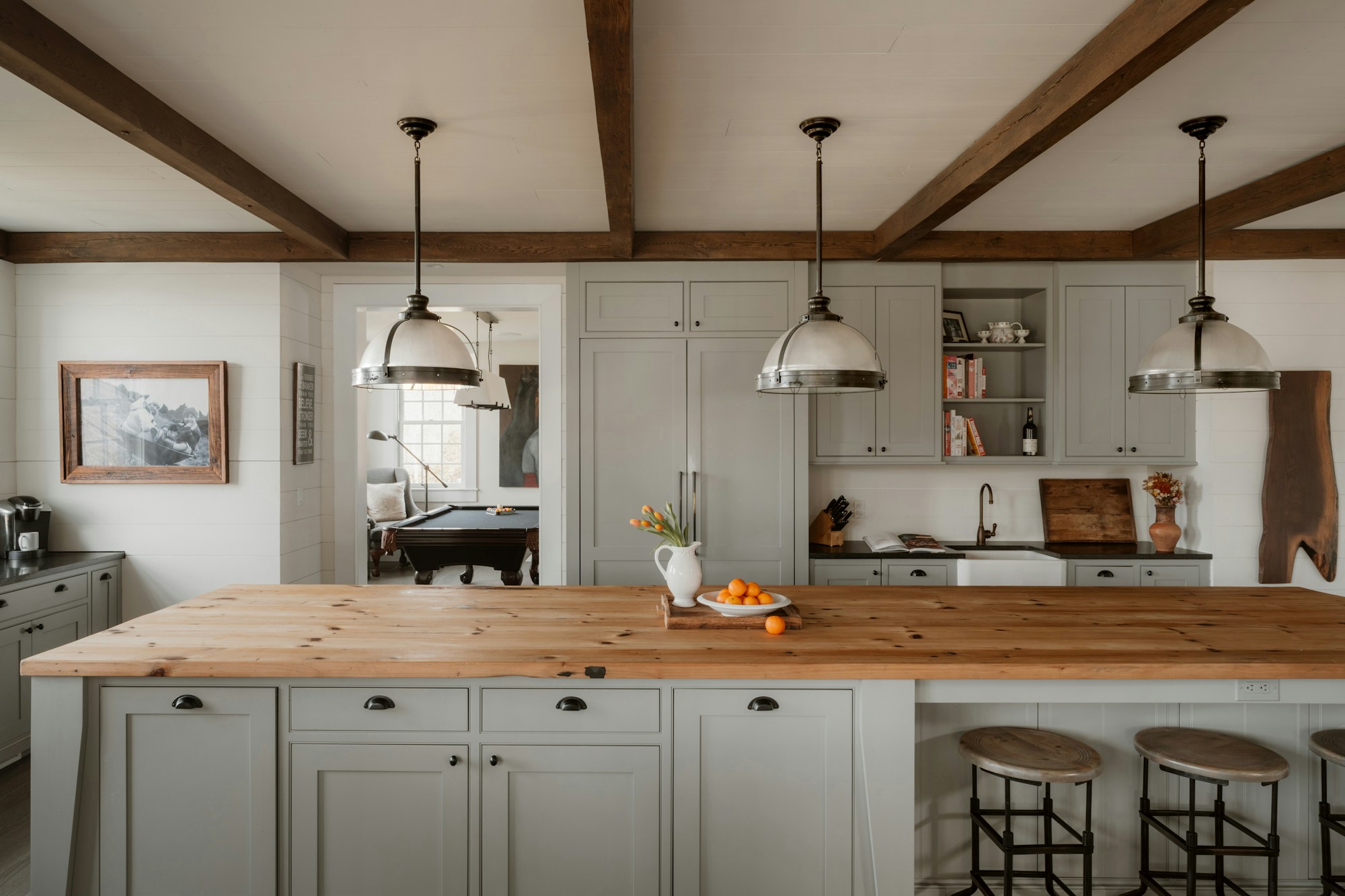Bright luxury kitchen and living space with brass lighting and marble surfaces